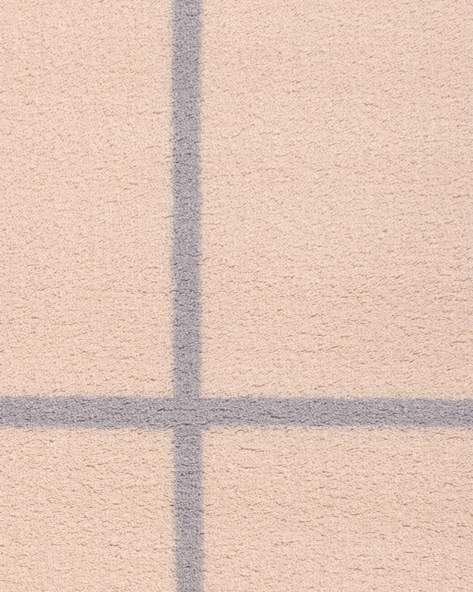 Dywan wełniany GRID - zbliżenie na dywan wełniany z wyraźnym wzorem w kratkę.
