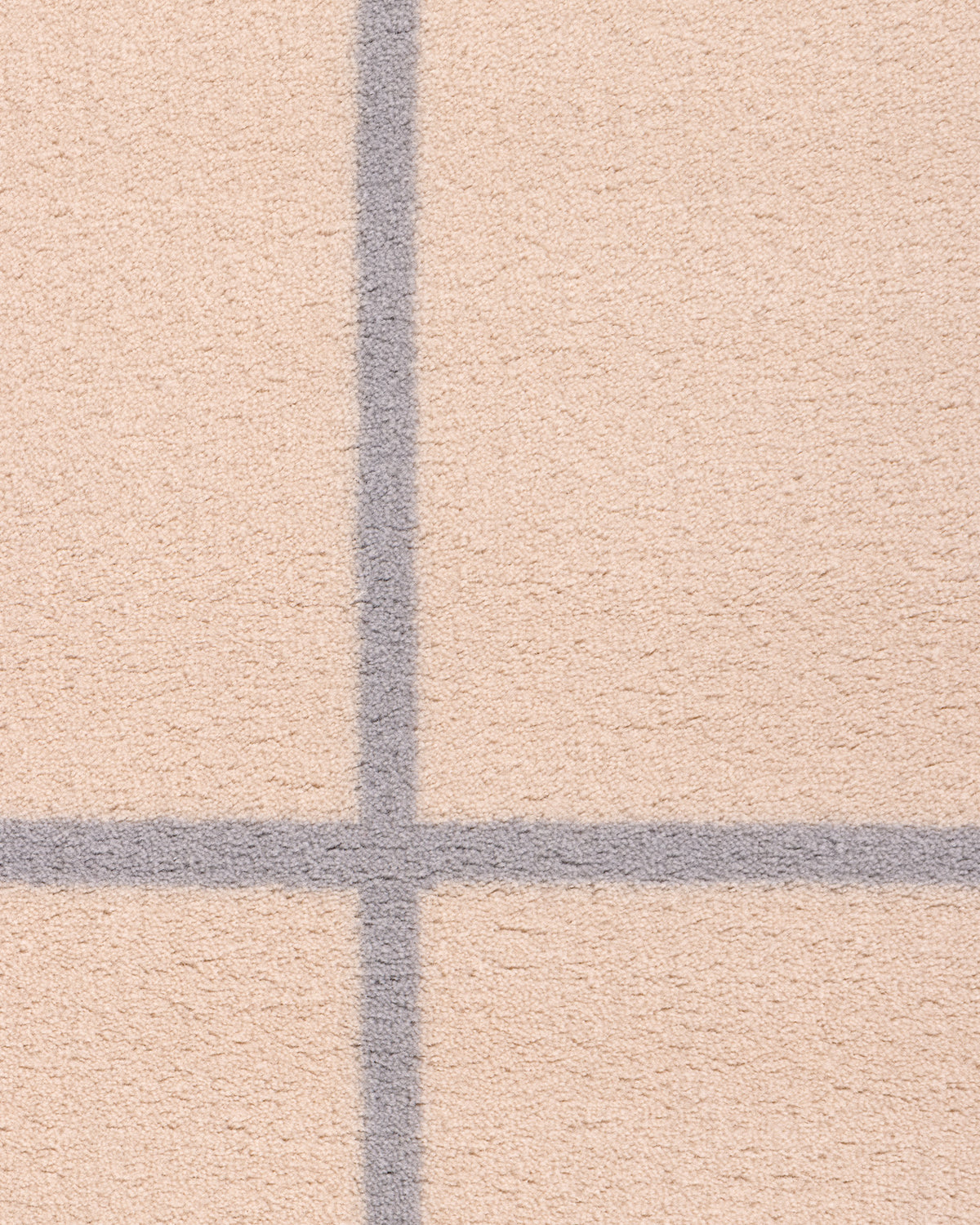 Dywan wełniany GRID - zbliżenie na dywan wełniany z wyraźnym wzorem w kratkę.