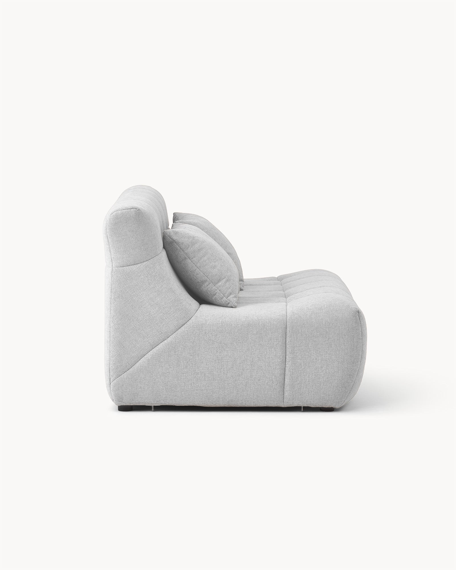 Sofa dwuosobowa SHAPE - widok z boku na dwuosobową sofę z poduszkami na oparciu i wyraźnym kształtem.