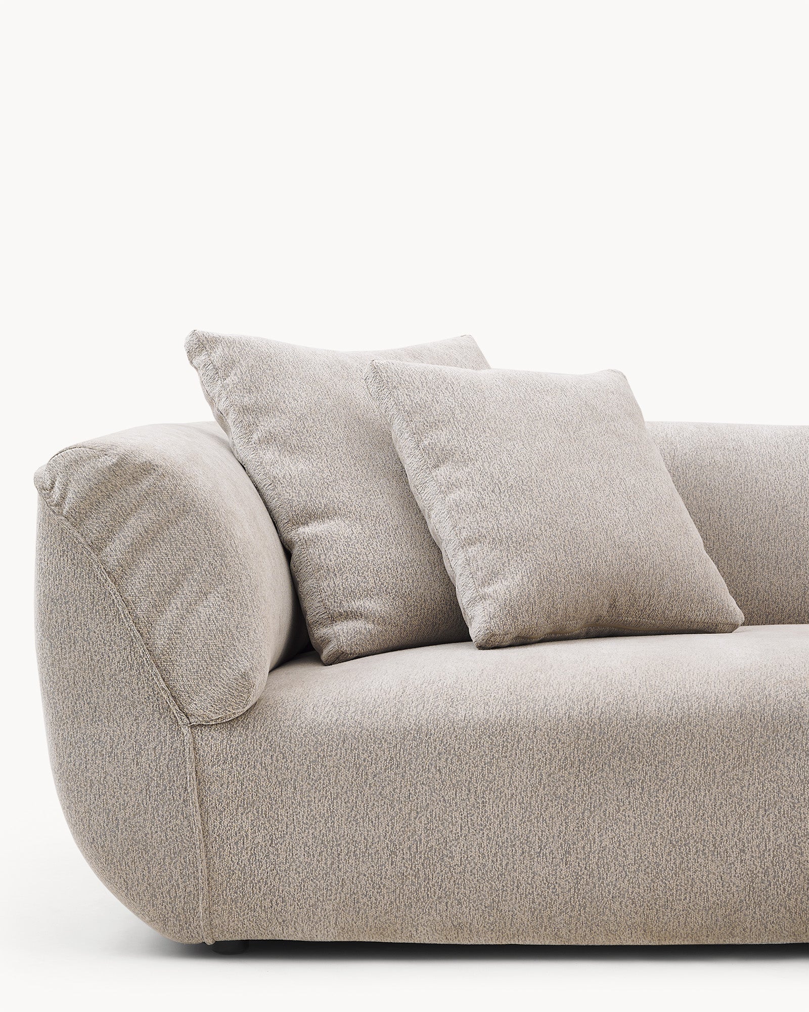 Poduszka dekoracyjna VIBE 60 cm x 60 cm - poduszka dekoracyjna leży na kanapie, w towarzystwie dwóch mniejszych poduszek. Ujęcie z boku ukazuje jej kształt i detale.