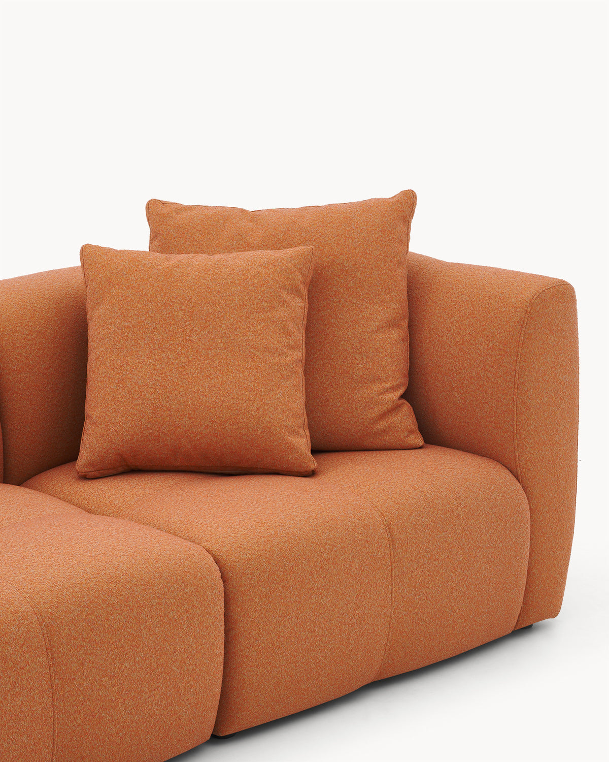 Sofa modułowa AURA (2 el.) - zbliżenie na sofę modułową z poduszkami, ukazujące jej zaokrąglone kształty.