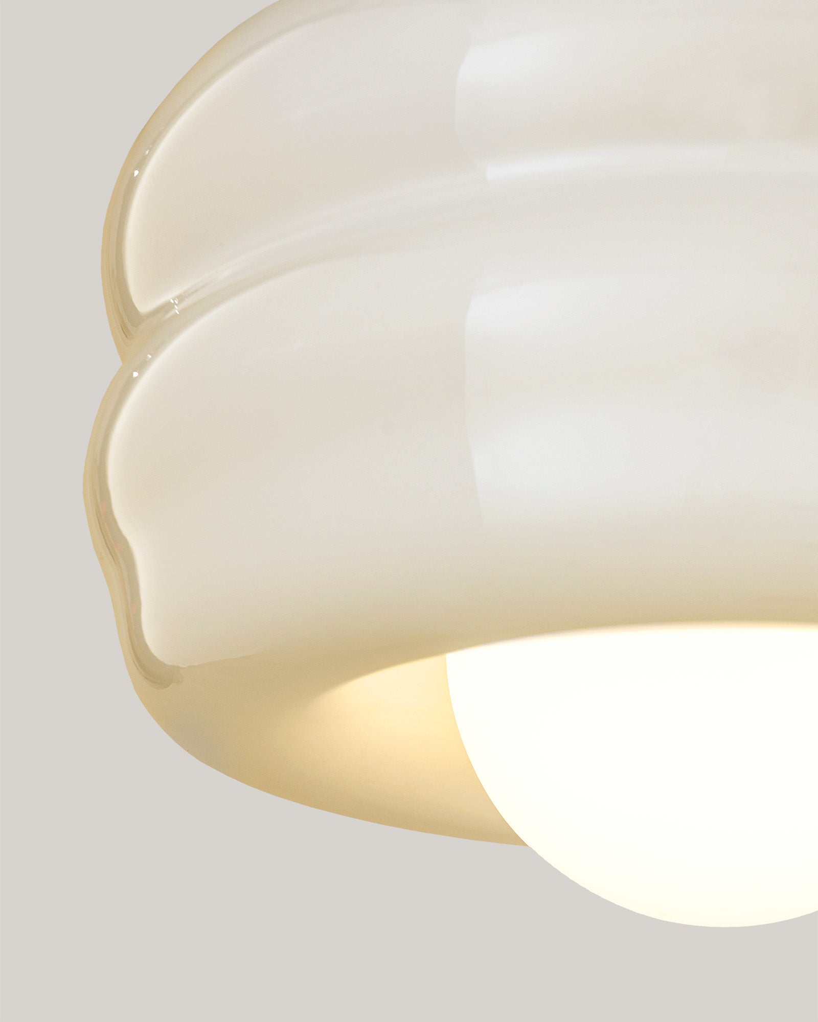 Lampa BUNS - zbliżenie na lampę z okrągłym kloszem i falistym wykończeniem. Widok z boku ukazuje detale konstrukcji.
