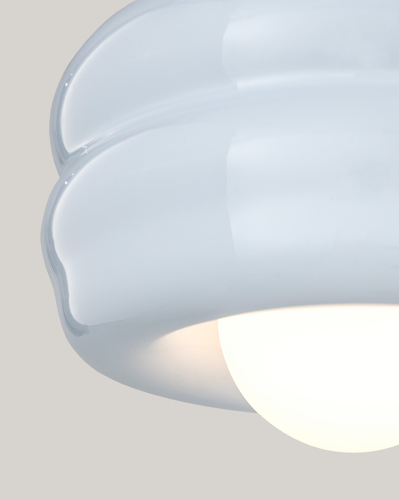 Lampa BUNS - zbliżenie na lampę z okrągłym kloszem i falistym wykończeniem. Widok z boku ukazuje detale konstrukcji.